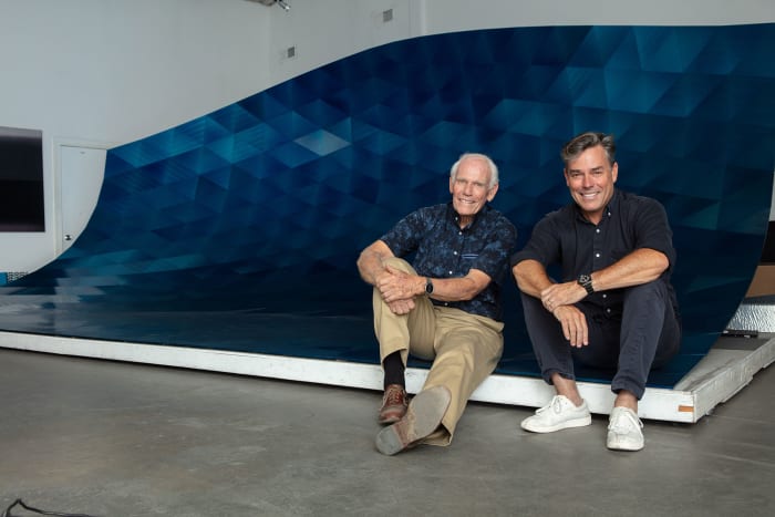 Alex Rasmussen with his father, Neal Charles Rasmussen, inside the curl of the 24-foot-long modular blue wave. 