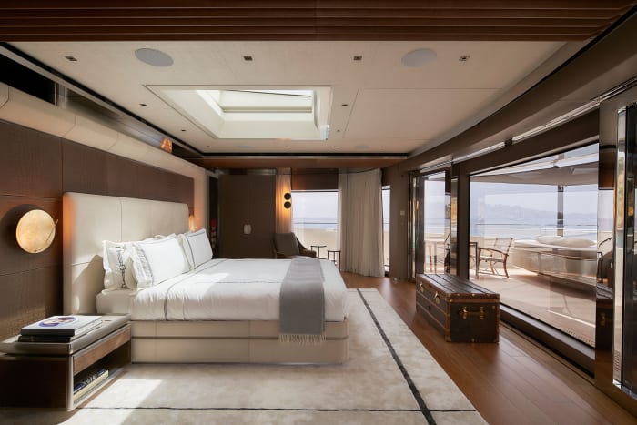 The master stateroom on the owner’s deck provides panoramic views though the full-height sliding doors over the foredeck and a private pool—one of three on the yacht. 