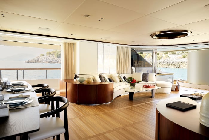 The main salon opens directly onto the aft deck through a grand semicircle of sliding glass. 
