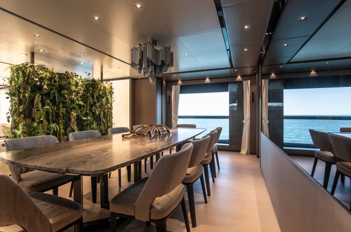 A living screen of green plants separates the salon and dining area. 