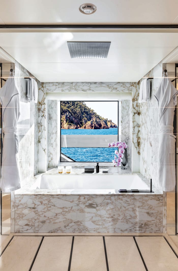 When the sliding doors between the owner’s dressing room and bathroom are open, there is a direct line of sight across the full beam of the yacht. 