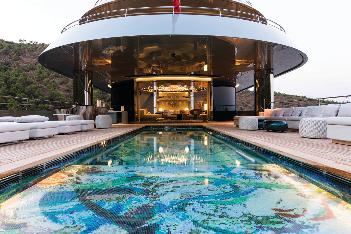 The 30-foot-long main-deck swimming pool is custom tiled in a variety of blues and greens, forming an eye-catching abstract work of art. This pool deck is flush to the main salon, enhancing the flow between inside and out.
