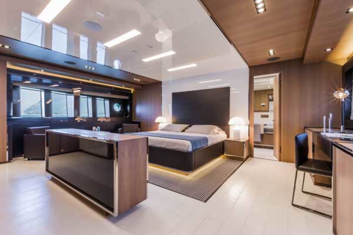 The full-beam master stateroom, finished in wood, leather and stainless, has a centerline stowage unit that conceals a pop-up 46-inch TV.