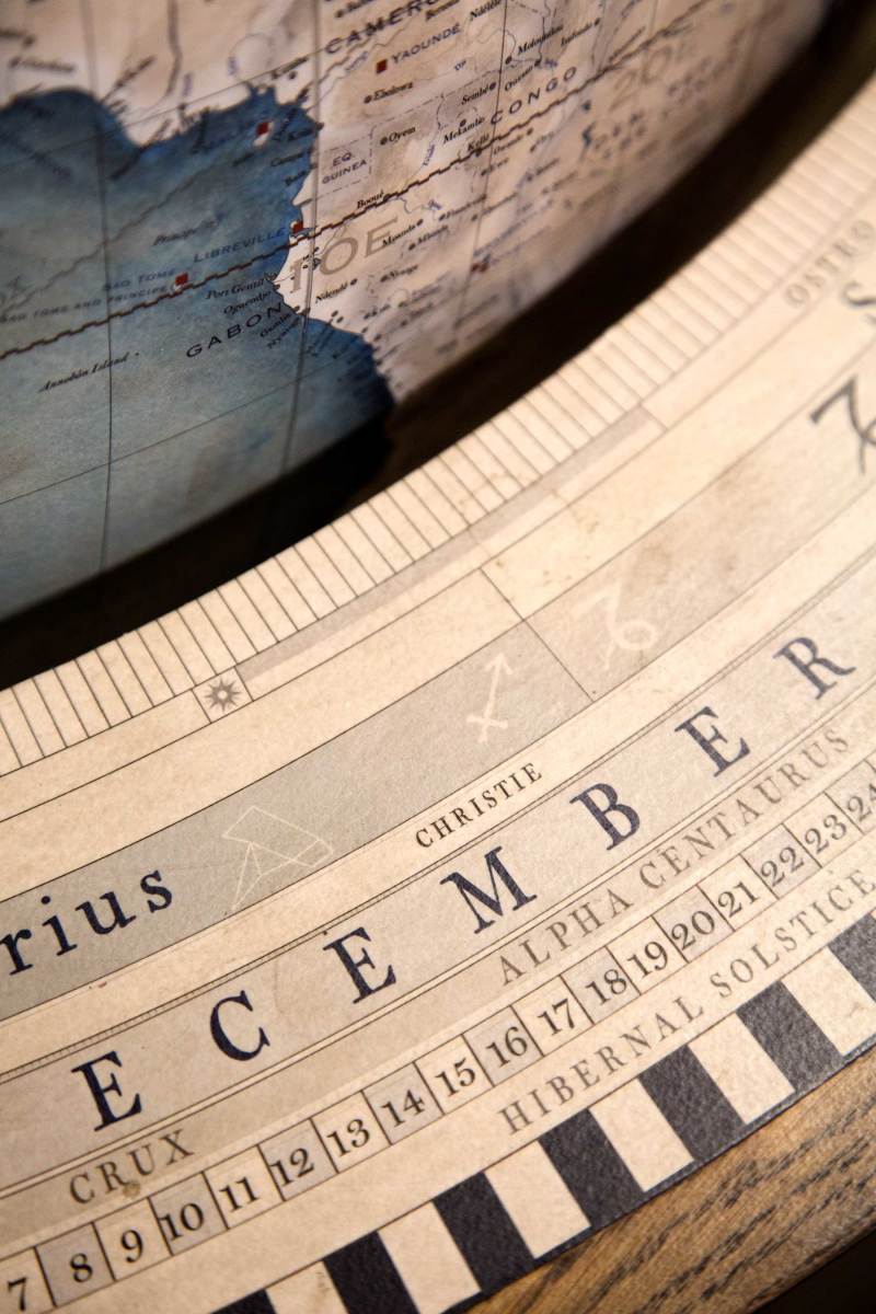 The horizon band, printed and painted on paper, is applied to the wood table that supports the globe. 