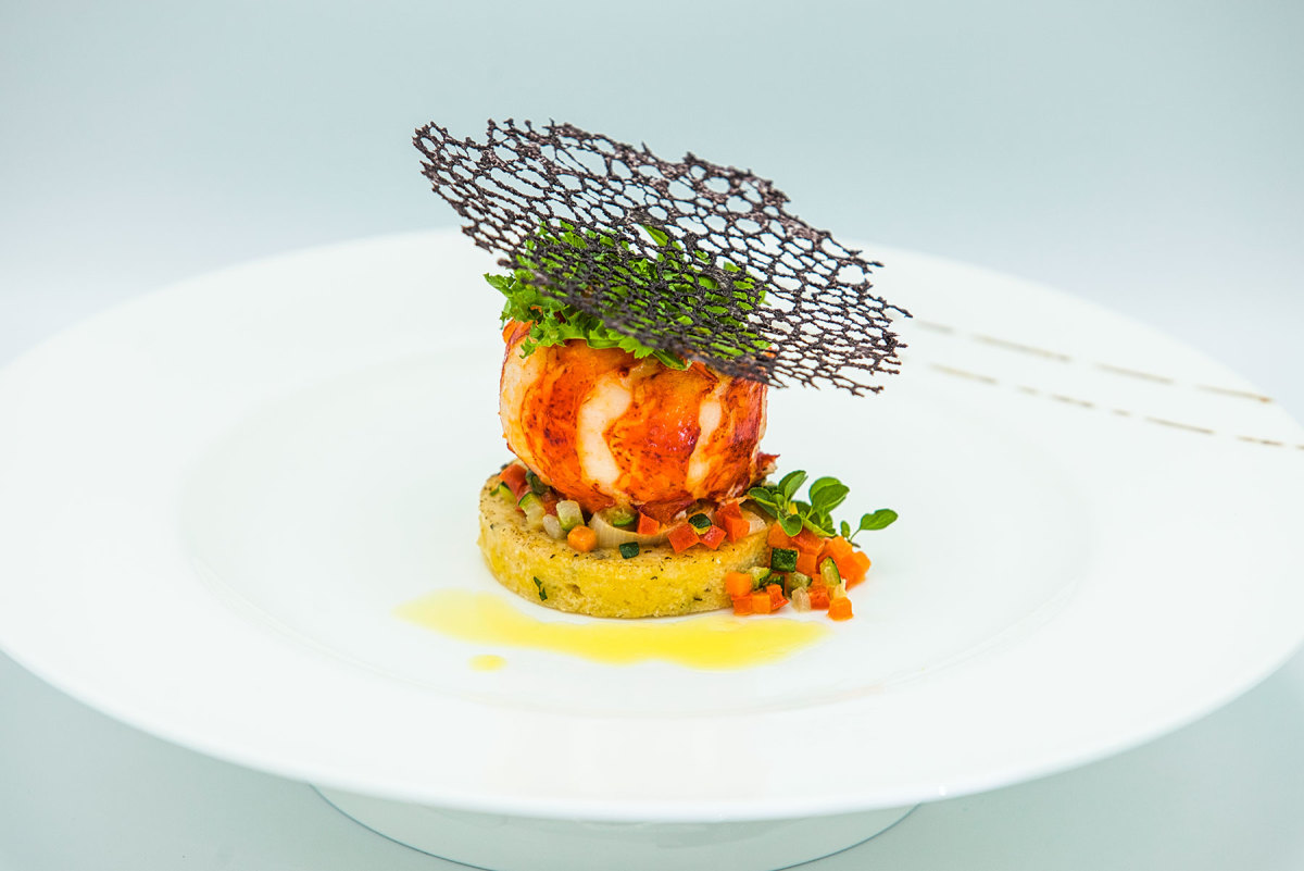 The chef’s award-winning butter-poached lobster tail on a polenta round with brunoise, braised leeks and coral tuille.