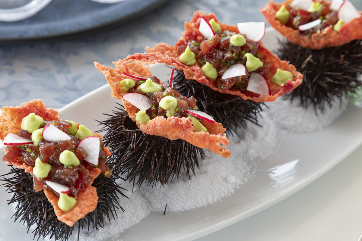 An appetizer of freshly caught tuna with local ingredients presented atop a sea urchin by the chef of Navilux.undefined